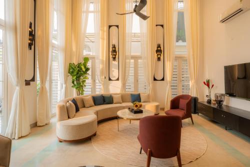 a living room with a couch and chairs and a tv at ELIVAAS 4 BHK Villa with Pvt Pool & Jacuzzi-Yashgeet in Siolim