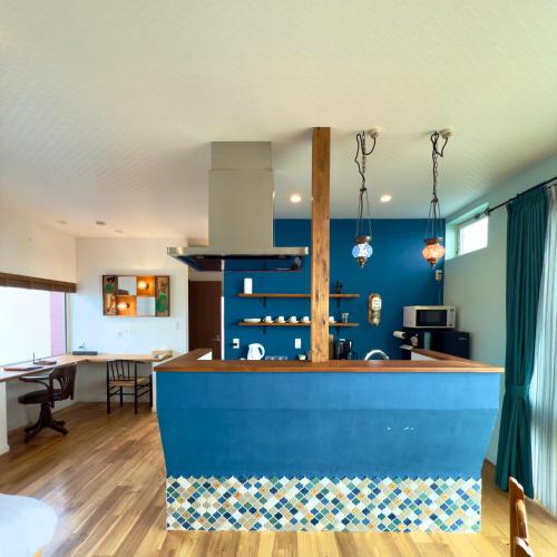 a kitchen with blue walls and a blue counter top at Seaside Inn KOKOMO in Hakodate