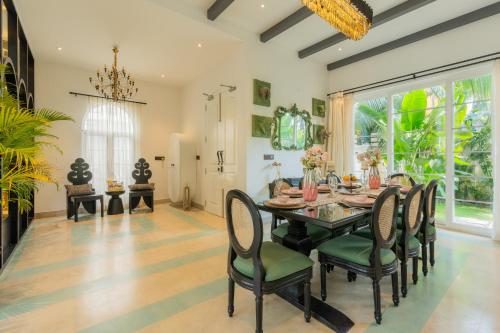 a dining room with a table and chairs at ELIVAAS 4 BHK Villa with Pvt Pool & Jacuzzi-Yashgeet in Siolim