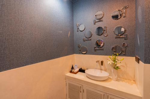 a bathroom with a sink and mirrors on the wall at ELIVAAS 4 BHK Villa with Pvt Pool & Jacuzzi-Yashgeet in Siolim