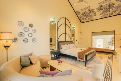 a bedroom with a bed and a living room at ELIVAAS 4 BHK Villa with Pvt Pool & Jacuzzi-Yashgeet in Siolim