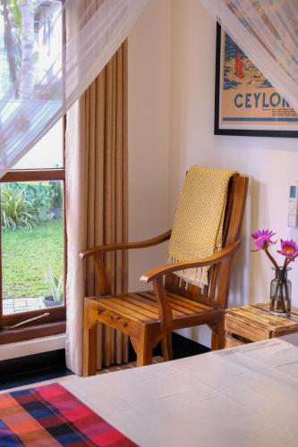 a bedroom with a rocking chair and a window at K O C O O N Villa Madiha in Walgama South