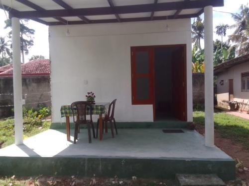 una casa con 2 sillas y una mesa en un porche en Green House Rooms, en Mirissa