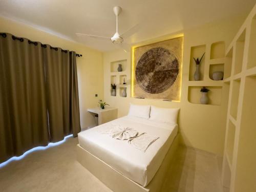 a bedroom with a white bed and a window at Kibanda Lodge and Beach Club in Nungwi