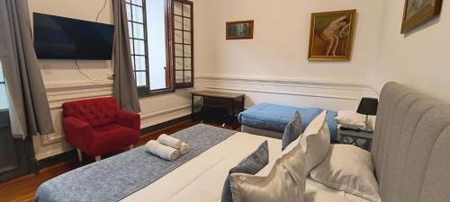 a room with two beds and a couch and a chair at Casa Marina Huérfanos in Santiago