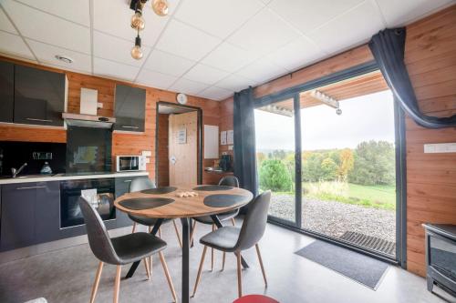 une cuisine et une salle à manger avec une table et des chaises dans l'établissement Chalet accueillant à Saint-Sylvestre avec baignade nordique, à Saint-Sylvestre