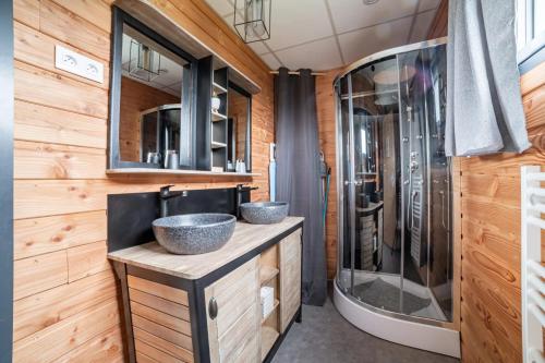 une salle de bain avec deux lavabos et une douche dans l'établissement Chalet accueillant à Saint-Sylvestre avec baignade nordique, à Saint-Sylvestre