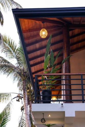 a balcony of a house with a palm tree at K O C O O N Villa Madiha in Walgama South