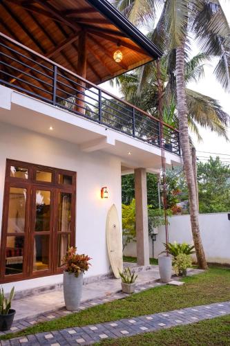 a house with a surfboard sitting outside of it at K O C O O N Villa Madiha in Walgama South