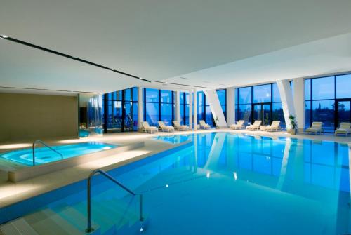 a swimming pool in a hotel with chairs and windows at Maistra Select All Suite Island Hotel Istra in Rovinj