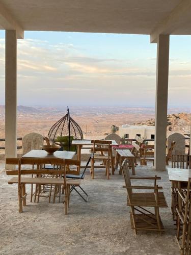 a group of tables and chairs with a view of the desert at Dar Fatma Toujane in Tūjān