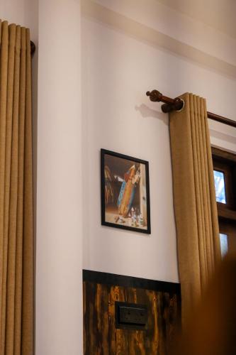 a picture hanging on a wall with curtains at K O C O O N Villa Madiha in Walgama South