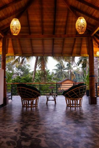 a group of chairs sitting under a pavilion at K O C O O N Villa Madiha in Walgama South
