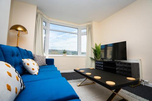 a living room with a blue couch and a tv at Haven in Bath
