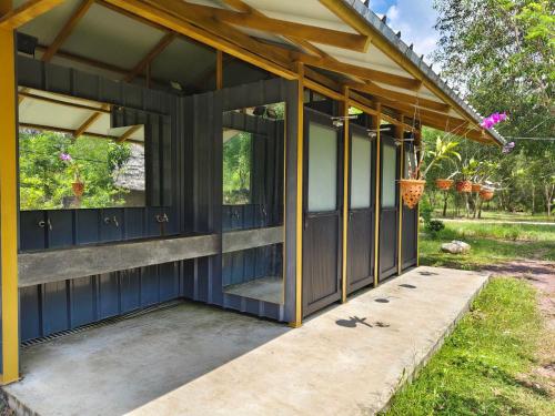 a house with a blue exterior with large windows at Kampot Camping - Eco Retreat in Kampot