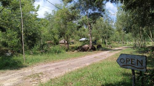 an open sign on the side of a dirt road at Kampot Camping - Eco Retreat in Kampot