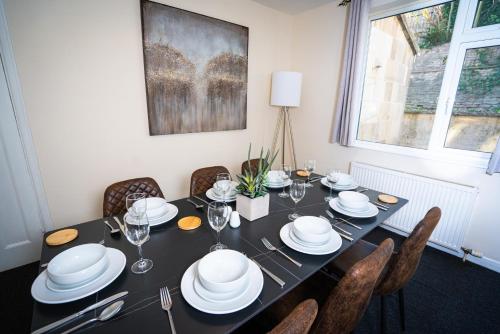 a dining room table with white plates and silverware at Haven in Bath
