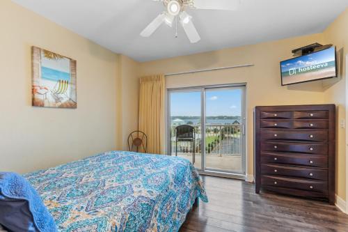 a bedroom with a bed and a dresser and a sliding glass door at Crystal Tower Condos in Gulf Shores