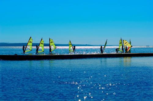 a group of people on a pier with sailboats in the water at Maistra Select All Suite Island Hotel Istra in Rovinj