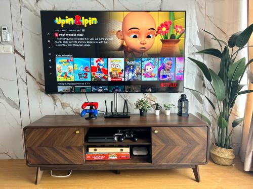 a entertainment center with a flat screen tv on a wall at GAIA RESIDENCE Gamuda Garden Rawang Skyline Luge in Rawang