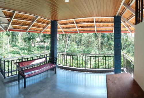 a porch with a bench and a view of trees at Cherry Stay in Cherambane