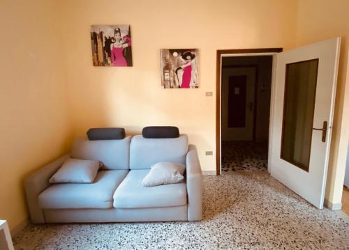 a living room with a white couch and pictures on the wall at Casa Maddalena in Casal Fiumanese