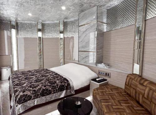 a bedroom with a bed and a couch and windows at ホテル　センチュリーアネックス in Chiba