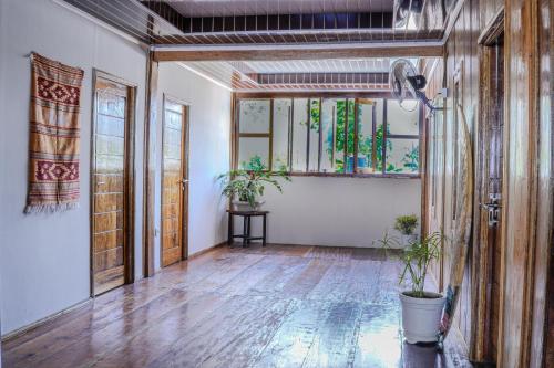 an empty room with wooden floors and stained glass windows at Maluk Surf House in Maluk