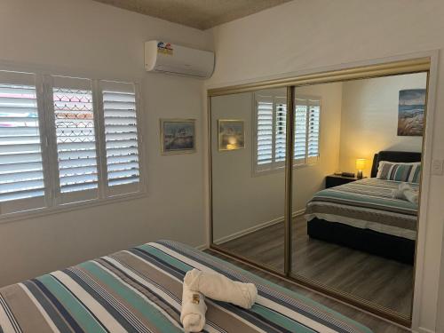 a bedroom with a mirror and a bed in it at Keith's Place, 1 of the 3 most popular units on Bribie in Bongaree