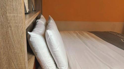 two white pillows sitting in a book shelf at Chill Roof Hotel in Taipei
