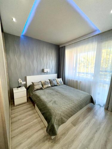 a bedroom with a bed with a blue ceiling at Downtown Dream Apartmans in Szeged