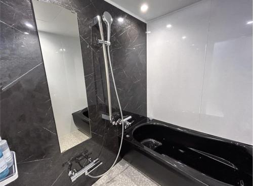 a bathroom with a black tub and a mirror at ホテル　センチュリーアネックス in Chiba