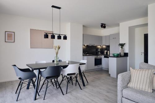 a kitchen and living room with a table and chairs at Maisonette-Apartment A11 - zwei Schlafzimmer, zwei Bäder, zwei Balkone & zwei Terrassen im "Pine Hill Resort" in Zirchow