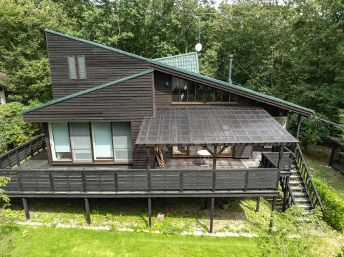 a house with a solar panel on the roof at 那須プレミアムハウス 高級感あふれる内装 カラオケ 卓球 薪ストーブ in Nasu