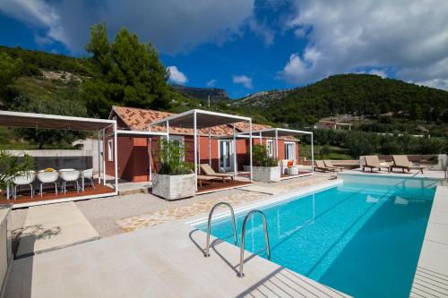 a villa with a swimming pool with mountains in the background at Modern Mediterranean Oasis - Villa ''BOLKA'' in Bol