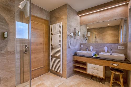 a bathroom with two sinks and a shower at Sonnenhotel Zum Stern in Bad Hofgastein