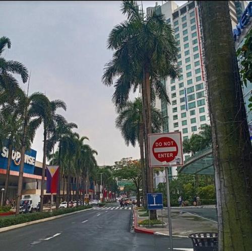 a do not enter sign on a street with palm trees at Cozy Corner at Manhattan Heights Tower B 2BR ,2BA Amazing View in Manila