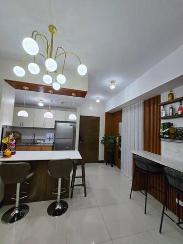 a kitchen with a counter and some chairs in it at Cozy Corner at Manhattan Heights Tower B 2BR ,2BA Amazing View in Manila