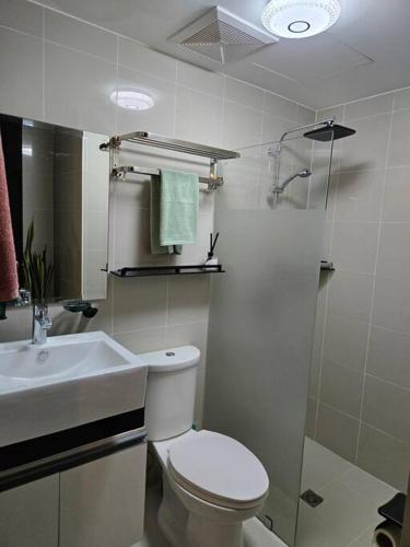 a bathroom with a toilet and a sink and a shower at Cozy Corner at Manhattan Heights Tower B 2BR ,2BA Amazing View in Manila