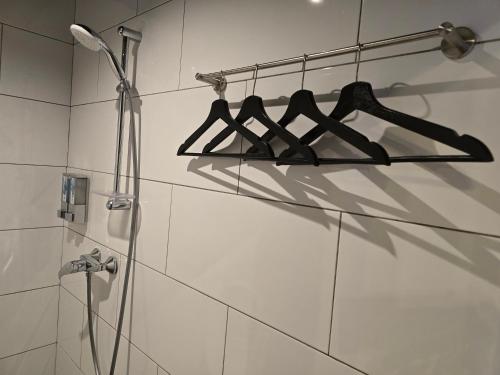 a bathroom with a shower with hangers on the wall at Space Hotel KL Sentral in Kuala Lumpur