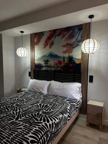 a bedroom with a bed with a painting on the wall at Hostal Fronton in Alcobendas