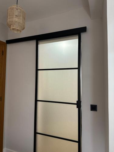 a sliding glass door in a white wall at Hostal Fronton in Alcobendas