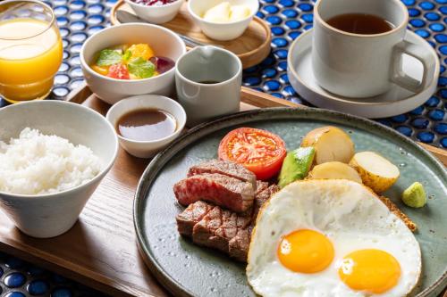 a plate of breakfast food with eggs meat and vegetables at Ace Hotel Kyoto in Kyoto