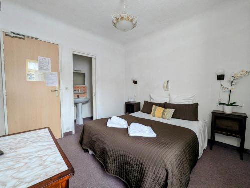 a bedroom with a large bed and a bathroom at L'Aiguebelle in Céreste