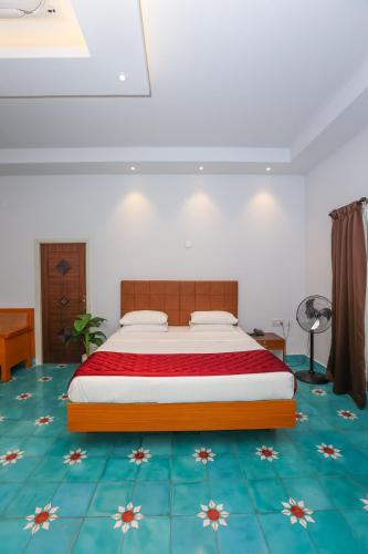 a bedroom with a bed and a blue floor at Nilan Zingle Resort in Puducherry
