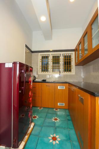 a kitchen with a refrigerator and a tile floor at Nilan Zingle Resort in Puducherry