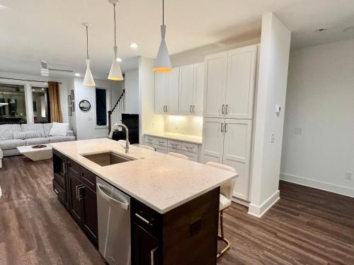 a kitchen with a sink and a living room at New Elevations Rooftop 5 Min to Downtown Nash in Nashville
