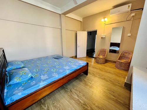 a room with a bed and two chairs in it at Heritage Inn Homestay in Sibsāgar