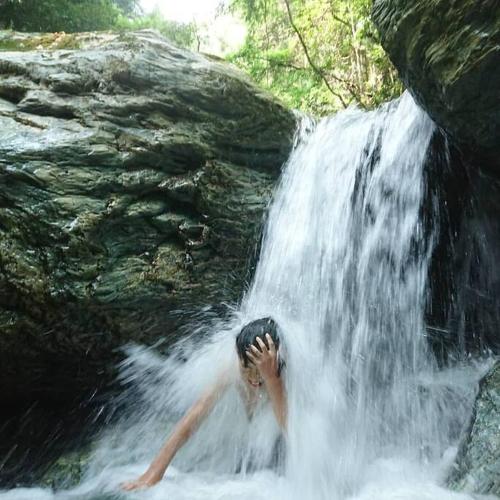 a person laying in the water under a waterfall at Oyamanoyado Michitsuji in Otoyocho