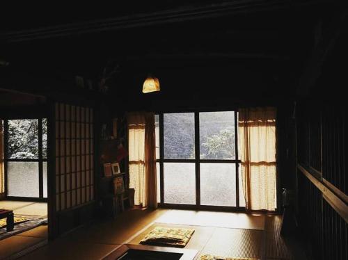 a living room with windows and a room with a table at Oyamanoyado Michitsuji in Otoyocho